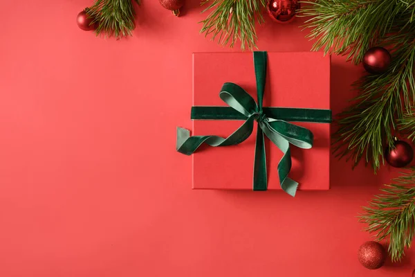赤いギフト付きのクリスマスお祝いのグリーティングカード 赤い背景の常緑の枝 Xmasバナー コピースペース 上からの眺め — ストック写真