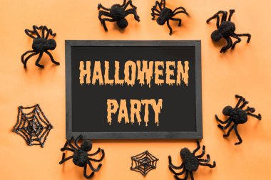 Cadılar Bayramı 'nda parti dekorasyonu, siyah örümcekler, turuncu üzerine ağ. Düz yatış, üst görünüm.