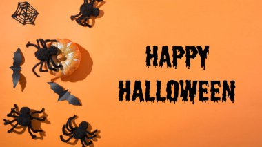 Ya cadılar bayramı boş ya da turuncu arka planda siyah örümcekler ve örümcek ağıyla eğlenceli bir parti için davetiye. Düz yatış tarzı, üst görünüm. Parti aksesuarları. Mutlu Cadılar Bayramı - metin.