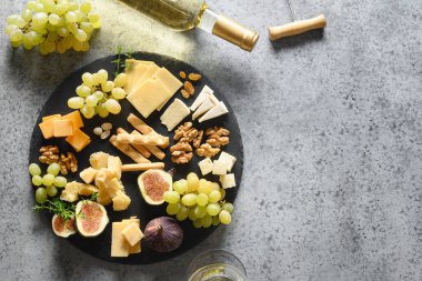 Üzümlü peynir tabağı, fındık, gri arka planda incir. Üst görünüm.