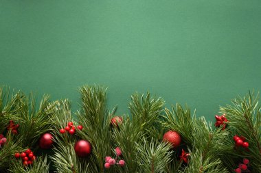 Çam dalları ve kırmızı topları olan bir Noel çerçevesi. Xmas tebrik kartı. - Mutlu yıllar. Yukarıdan bak, düz yat.