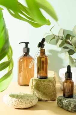 Bej bir zemin üzerinde doğal kozmetik ve organik yağ içeren, taş ve gölgeli minimum modern kompozisyon. Vücut bakımı için SPA ayarlandı.