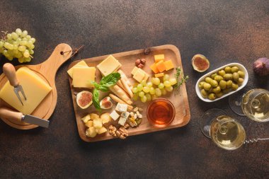 Üzümlü peynir tabağı, fındık, kahverengi arka planda incir. Üst Manzara. Bayram için gurme aperatifi.