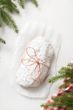 Noel çalıntısı. Beyaz arka planda geleneksel Alman ekmeği. Yukarıdan bak. Noel tatili meyveli keki. Christstollen. Dikey biçim.