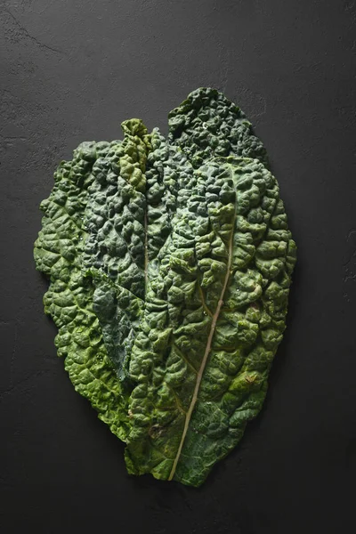 Färska blad av populära tuscan grönkål sallad på svart bakgrund. — Stockfoto