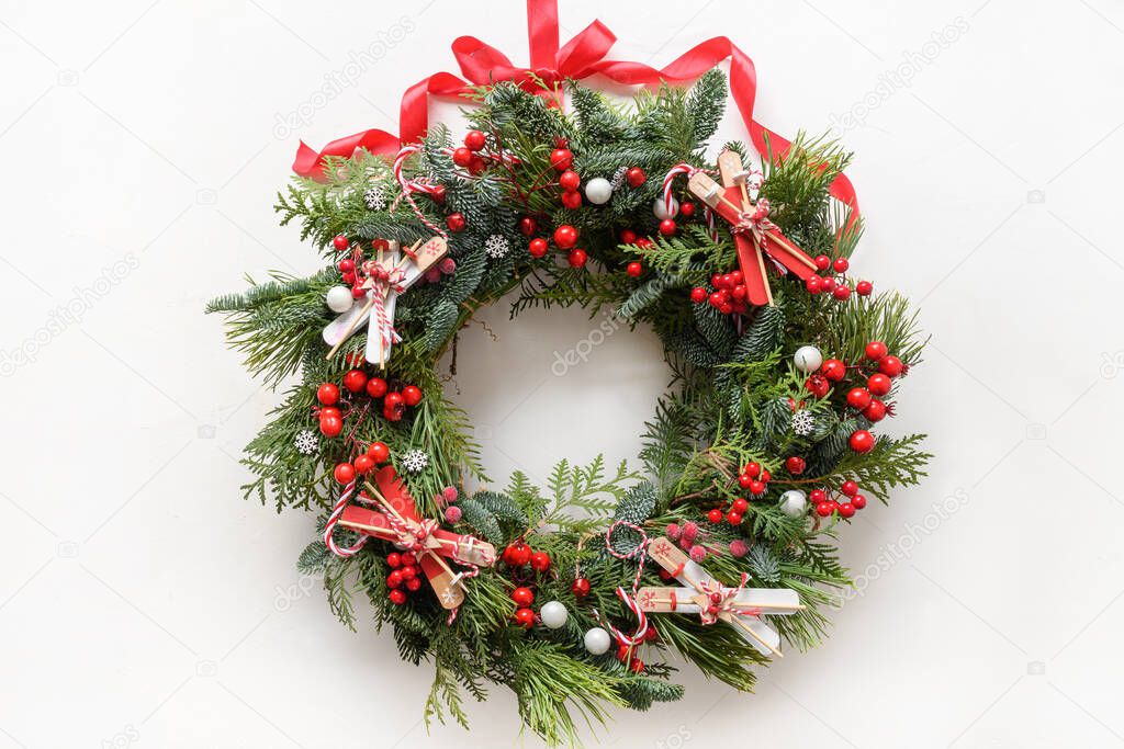 Christmas wreath of fresh natural spruce branch with red holly berries and decoration. New Year. Xmas holiday.