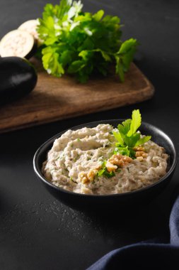 Baba ganoush Levantine mutfak aperatifi maydanozlu, sarımsaklı ve zeytinyağlı fırında patlıcan. Kapat..