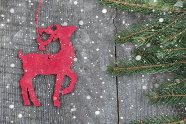 Decoración de venado de Navidad roja de madera sobre fondo de madera. Nieve dibujada . — Foto de Stock