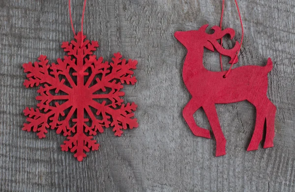 Ciervo de Navidad rojo madera y copos de nieve sobre fondo de madera. Vista superior . — Foto de Stock