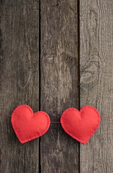 Два красных сердца красиво помещены на винтажном деревянном фоне — стоковое фото