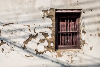 Paslı kırmızı bir pencere ile yaşlı duvar