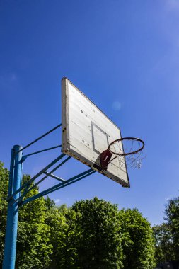 Basketbol potası mavi güneşli gökyüzüne karşı - fotoğraf. Okul spor aletleri, yarışmalar için kort. 21 Aralık Basketbol Günü, Doğum günü