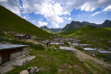 Avusor Platosu ve Kackar Dağları mavi bulutlu gökyüzü arka planına sahip. İskoçya ve eski evler