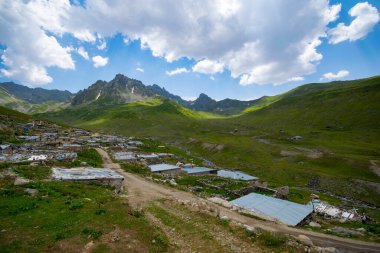 Avusor Platosu ve Kackar Dağları mavi bulutlu gökyüzü arka planına sahip. İskoçya ve eski evler