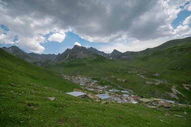 Avusor Platosu ve Kackar Dağları mavi bulutlu gökyüzü arka planına sahip. İskoçya ve eski evler