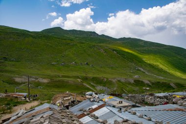 Avusor Platosu ve Kackar Dağları mavi bulutlu gökyüzü arka planına sahip. İskoçya ve eski evler