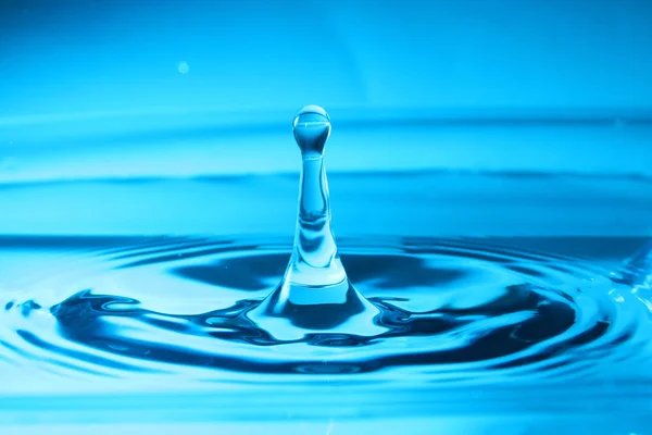 Waterdruppel met blauwe achtergrond — Stockfoto