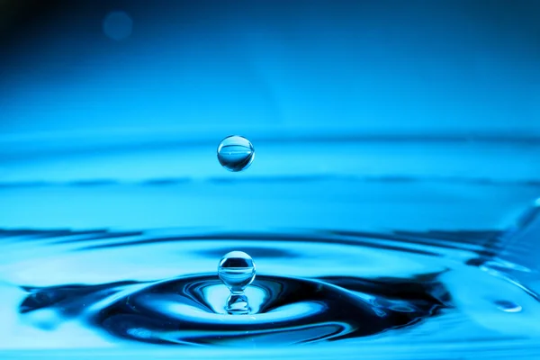 Падіння води з синім фоном — стокове фото