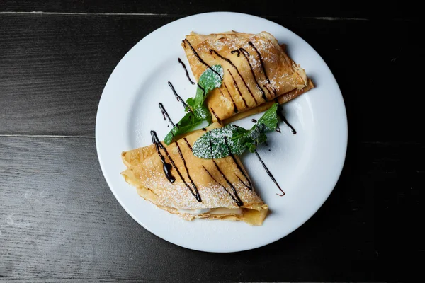 Çikolata nane ve koyu arka plan üzerine pudra şekeri ile Pancakes