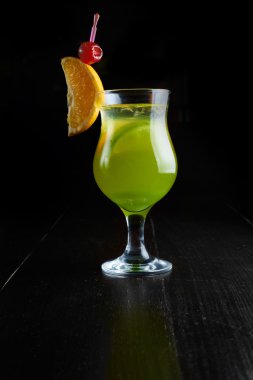 Narenciye ve kiraz koyu arka plan üzerinde yeşil kokteyl