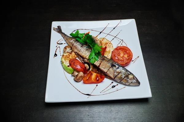Koyu arka plan üzerinde ızgara sebzeli balık