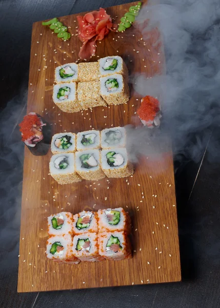 Koyu arka plan üzerinde ahşap bir gemide suşi rulo