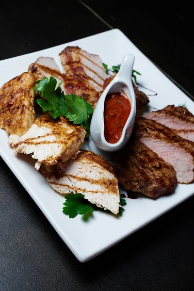 Koyu arka plan üzerinde soslu ızgara et