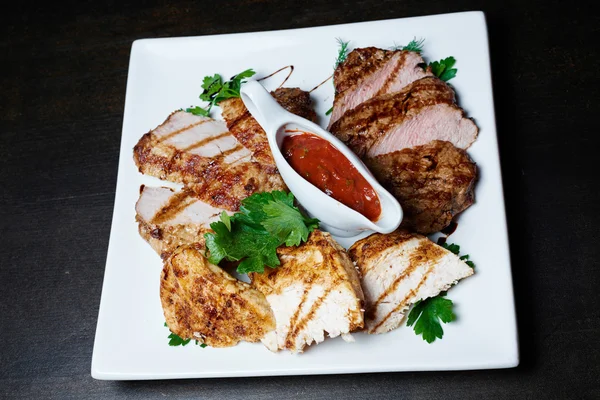 Koyu arka plan üzerinde soslu ızgara et