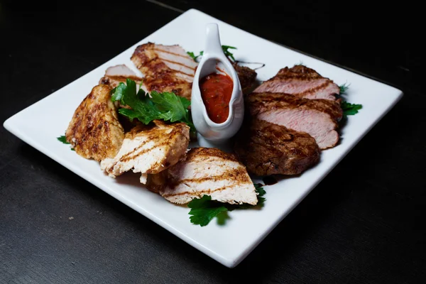 Koyu arka plan üzerinde soslu ızgara et