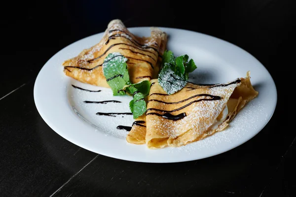 Çikolata nane ve koyu arka plan üzerine pudra şekeri ile Pancakes