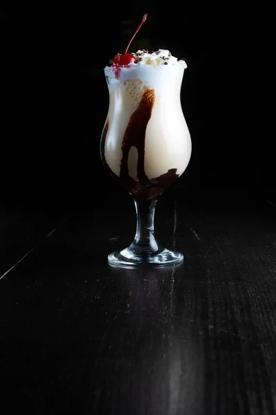 Milkshake çikolatalı krem şanti ve kiraz koyu arka plan üzerinde