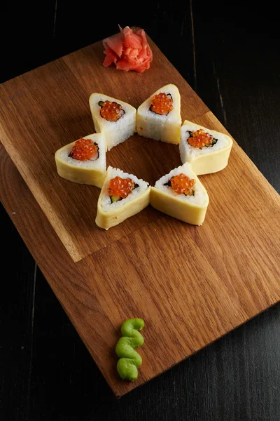 Koyu arka plan üzerinde ahşap bir gemide suşi roll