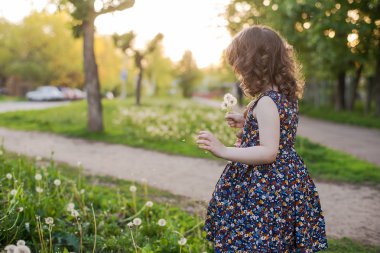 Onun elinde oyuncak ayı ile küçük kıvırcık kız
