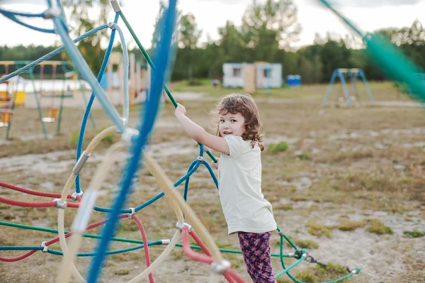 Liten flicka på lekplatsen med repstege — Stockfoto