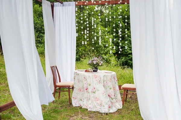 Outdoor gazebo with white curtains. Wedding decorations.