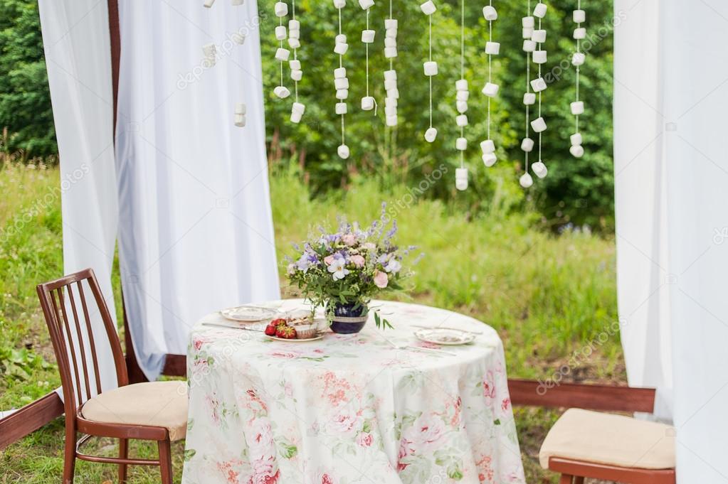 Outdoor gazebo with white curtains. Wedding decorations.