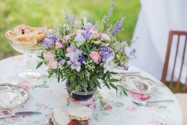 Tablo açık havada servis. Lavanta ve gül çiçek aranjmanı. Düğün süslemeleri.