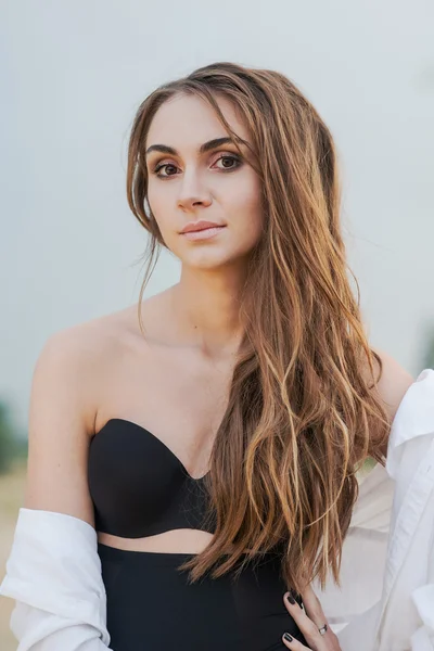 Piękna młoda kobieta brunetka czarny bielizna i białej koszuli na plaży — Zdjęcie stockowe