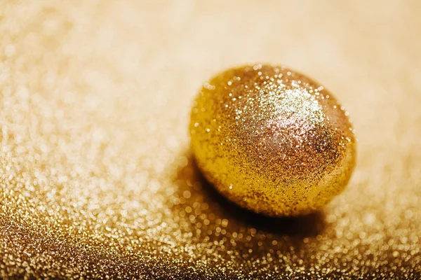Złote jajo na n błyszczące złote tło. Makro. — Zdjęcie stockowe