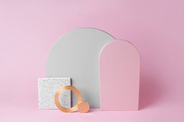 Pembe arka planda altın yuvarlak ve taş plakalı gri ve pembe kemerler. Çeşitli materyal ve geometrik şekillere sahip stil arkaplanı
