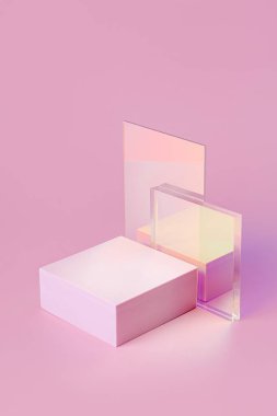 Geometrik şekiller ürün gösterimi için podyum oluşturur. Pembe arka planda parlak akrilik çarşaflı tek renkli platform. Sunum için şık bir zemin. Asgari biçim.