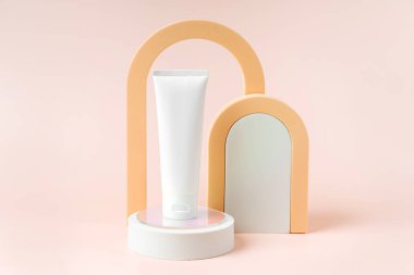 Podyumda kemerli krem tüp modeli. Marka ve ambalaj sunumu için arka plan. Doğal cilt bakım ürünleri konsepti.