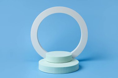 Mavi zemin üzerinde geometrik formlar olan kozmetik ürünleri göstermek için podyum. Marka ve ambalaj sunumu için arka plan. Doğal cilt bakım ürünü konsepti.