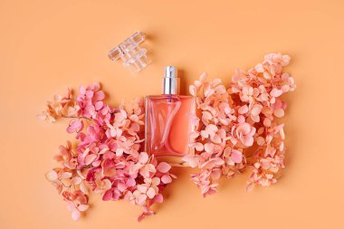 Pastel arka planda pembe çiçekli parfüm şişesi. Güzellik konsepti