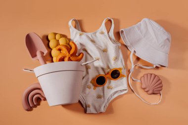 Çocuklar için plaj yaz aksesuarlarının en iyi manzarası. Moda mayosu, güneş gözlüğü, şapka ve plaj oyuncakları. Tatil için modern bir set. Düz yatıyordu