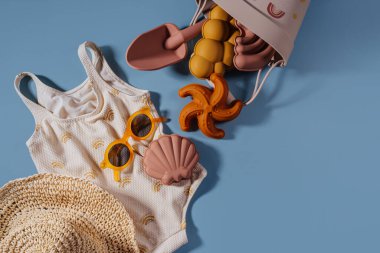 Çocuklar için plaj yaz aksesuarlarının en iyi manzarası. Moda mayosu, güneş gözlüğü, şapka ve plaj oyuncakları. Tatil için modern bir set. Düz yatıyordu