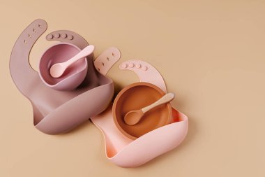 Çocuk sofra takımı ve silikon önlükler. Bebek aksesuarları. Beslenme ve beslenme konsepti. Üst manzara, düz uzanma