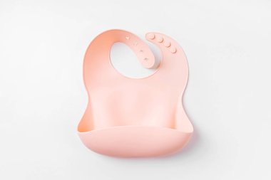 Beyaz arka planda pembe silikon bebek önlüğü. Üst manzara, düz uzanma
