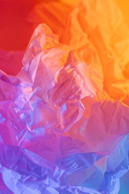 Buruşmuş kağıdın neon gradyanı ile soyut bir arkaplan. Canlı mavi, pembe ve turuncu renkler