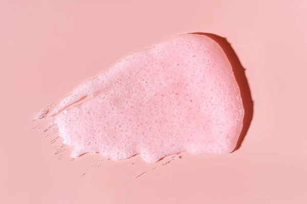 Scrub  smear on a pink background. Beauty texture. Sample of a cosmetic product.